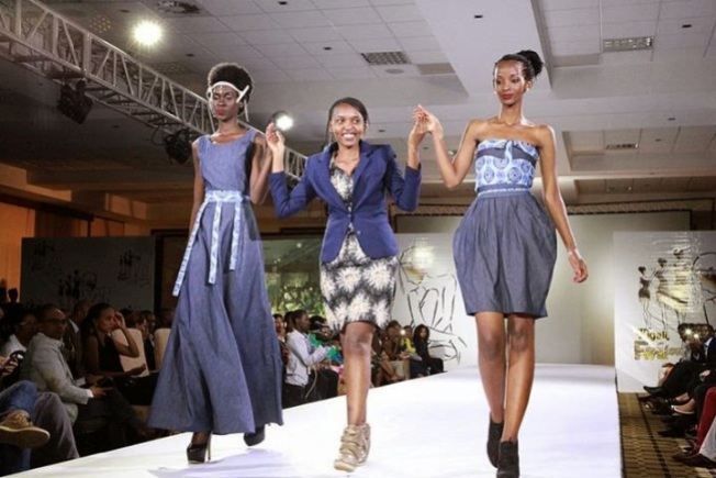 Colombe Ituze Ndutiye, Centre, walks with models cladding her pieces at the Kigali Fashion Week in November, 2013. (Courtesy photo)